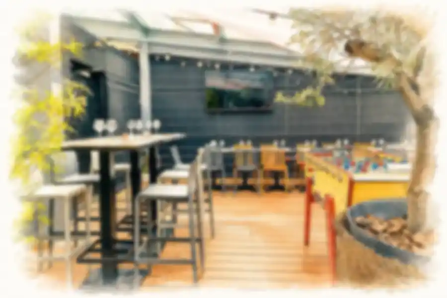 La terrasse couverte du Beerstro à Lille, avec tables hautes, olivier et babyfoot